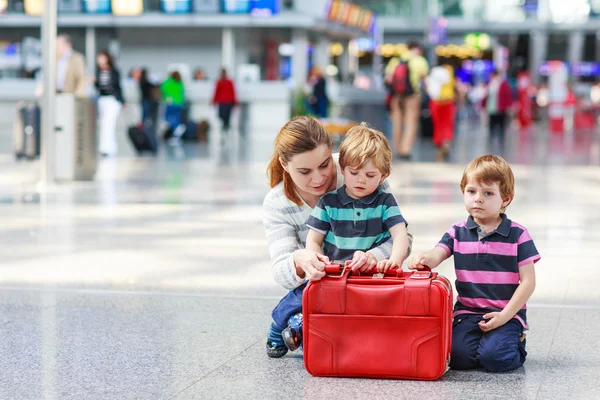 Mutter und zwei kleine Geschwister am Flughafen — Stockfoto