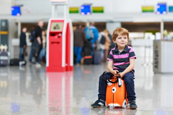 Liten pojke går på semester resa med resväska på flygplats — Stockfoto