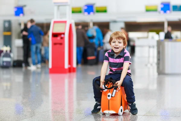 Liten pojke går på semester resa med resväska på flygplats — Stockfoto