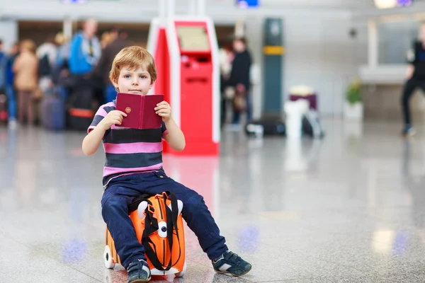 小さな男の子の空港でスーツケースの休暇旅行に行く — ストック写真