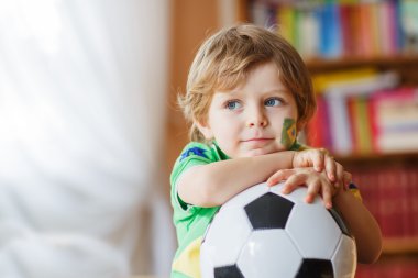 küçük çocuk televizyonda Futbol Kupası maç izlerken.
