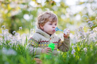 mutlu küçük çocuk çiçeklenme ile bahar bahçe beyaz çiçekler