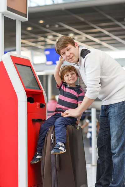 Father and little son at the airport, traveling together