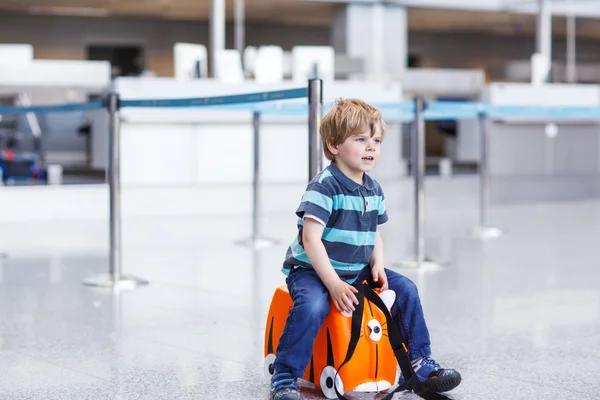 Liten pojke går på semester resa med resväska på flygplats — Stockfoto