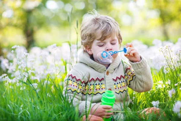 Niño feliz en el jardín de primavera con flores blancas en flor —  Fotos de Stock