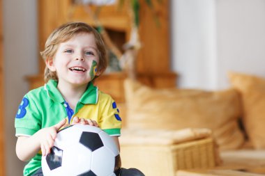 küçük çocuk televizyonda Futbol Kupası maç izlerken.