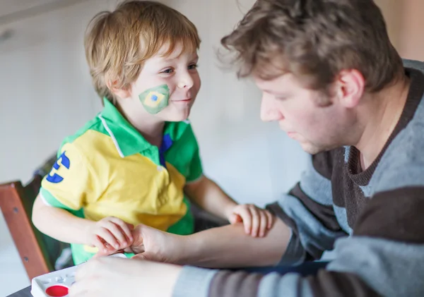 Father painting flag on face of little son — Stock Photo, Image