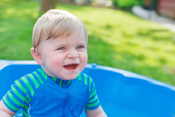 Roztomilá blonďatá batole chlapce hrát si s vodou, venku. — Stock fotografie