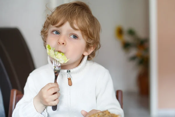 Lilla pojken äta sallad och bröd hemma, sunda matvanor för ki — Stockfoto