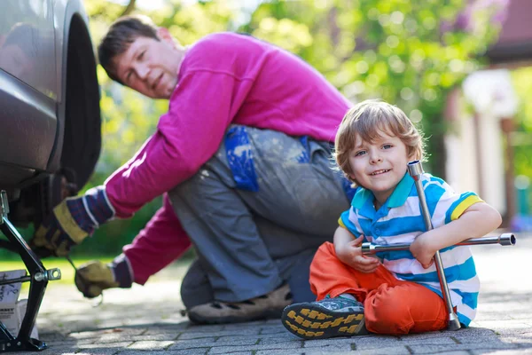 Vater und entzückender kleiner Junge reparieren Auto und wechseln Rad — Stockfoto