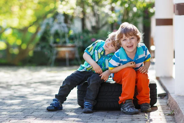 Два маленьких мальчика обнимаются и веселятся на улице. — стоковое фото