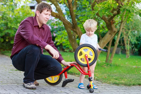 2 つの小さな兄弟男の子の父との自転車の車輪を修理 — ストック写真