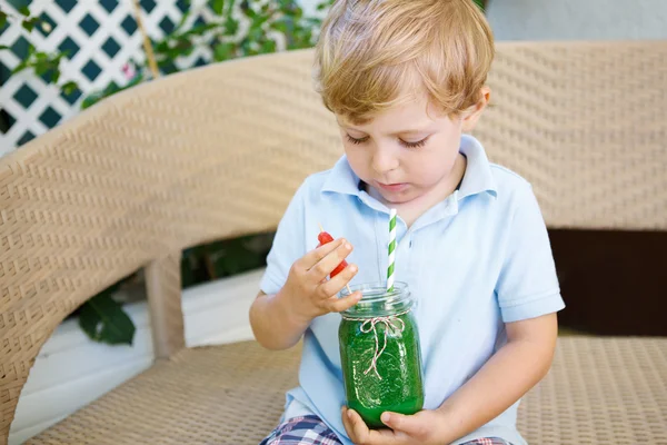 Kleiner blonder Junge trinkt im Sommer gesunden Wassermelonensaft. — Stockfoto