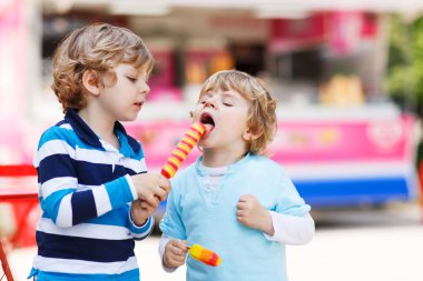 iki çocuk birbirlerini dondurma ile besleme