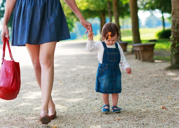 Glad ung mamma och bedårande barn girl går genom summan — Stockfoto