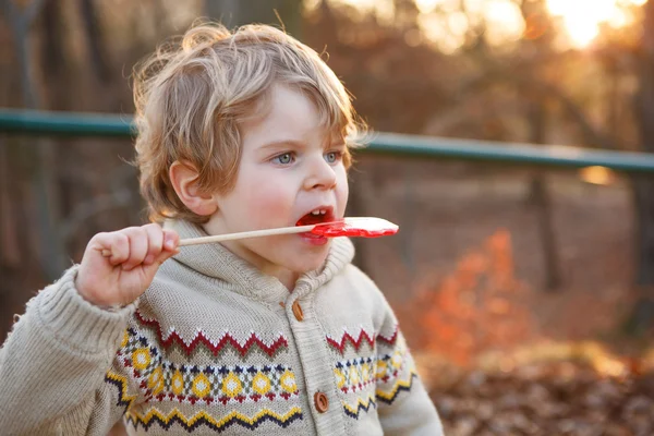 Portrait of beautiful little boy of 2 with big candy, outdoors — Stock Photo, Image