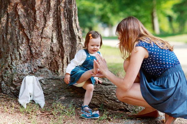 Happy young mother and adorable toddler girl walking through sum — Stock Photo, Image