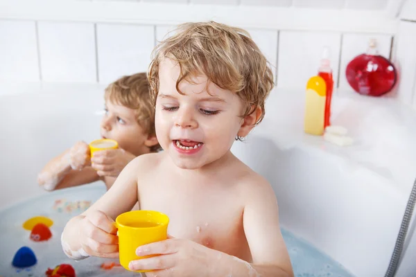 Twee kleine tweeling jongens plezier maken met water door rekening bad in ba — Stockfoto