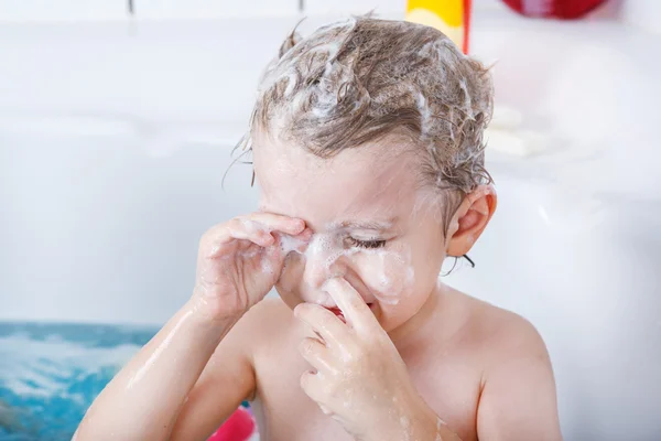 Schattige kleine peuter jongen van twee jaar met plezier door het nemen van bad ik — Stockfoto