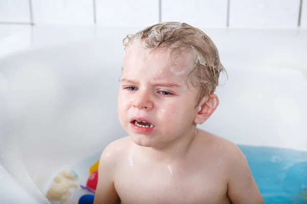 Schattige kleine peuter jongen van twee jaar met plezier door het nemen van bad ik — Stockfoto
