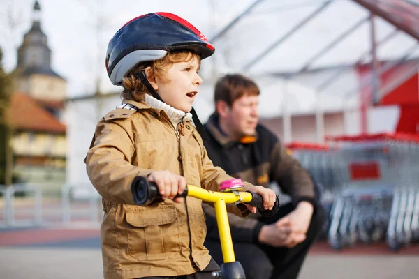 Lilla barn pojke med cykel och hans far i staden — Stockfoto
