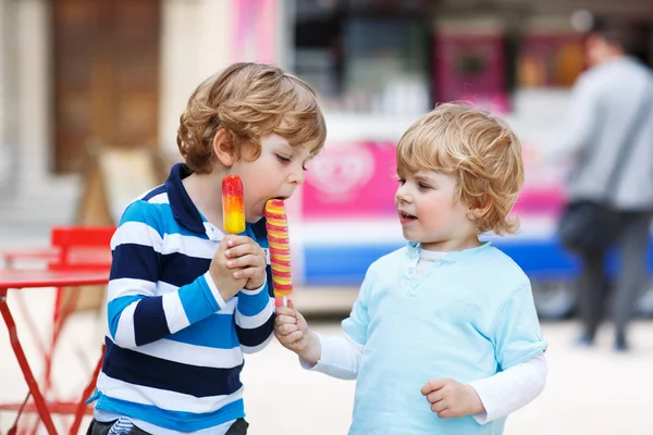 Двое детей кормят друг друга мороженым — стоковое фото