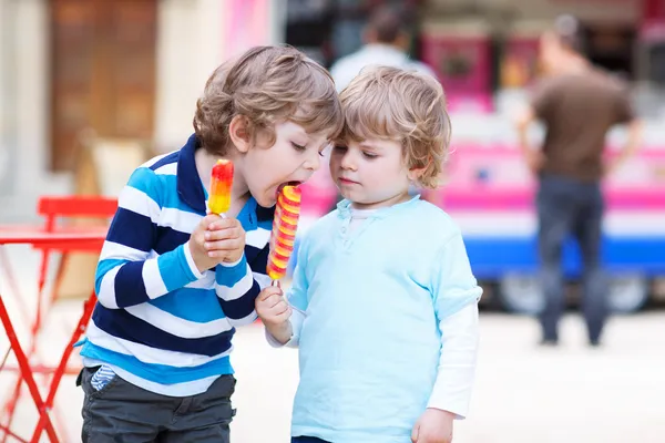 Двоє дітей годують один одного морозивом — стокове фото