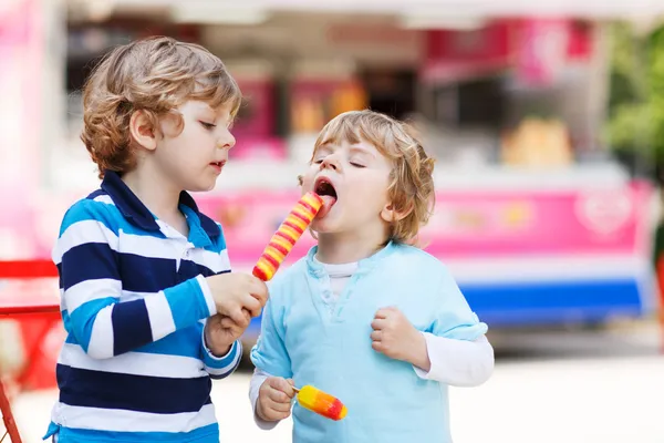 Two kids feeding each other with ice cream — Stock Photo, Image
