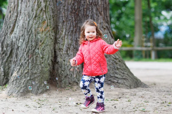 Süßes kleines Mädchen hat Spaß mit Seifenblasen — Stockfoto