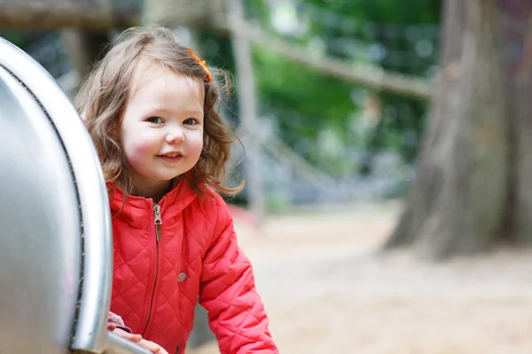 Petite fille mignonne qui s'amuse sur l'aire de jeux — Photo