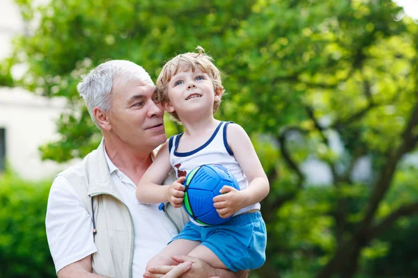 Active grandfather playing with little grandson ball — Stock Photo, Image