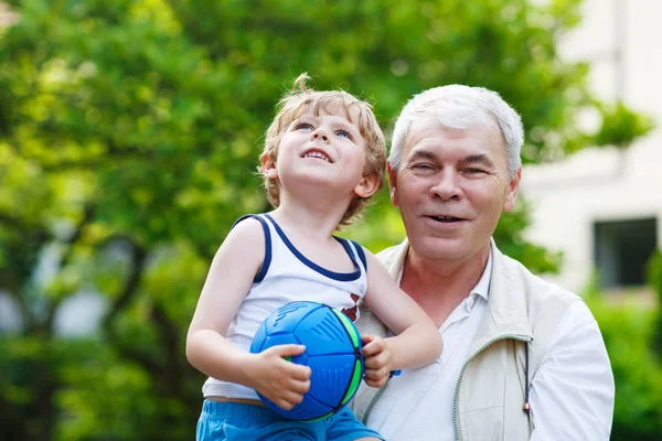 Active grandfather playing with little grandson ball — Stock Photo, Image