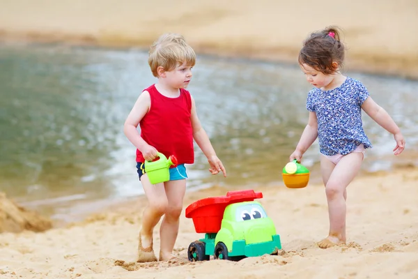 Little toddler boy and girl playing together with sand toys — Stock Photo, Image