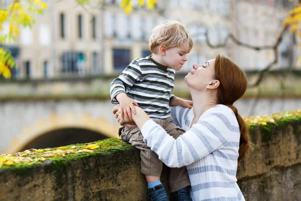 Liebenswerter kleiner Sohn und Mutter in der Herbststadt. — Stockfoto