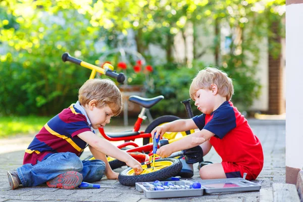 Dwóch chłopców rodzeństwo naprawianie uszkodzony rower — Zdjęcie stockowe