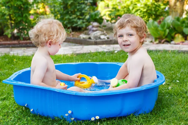 Dos hermanos que se divierten con el agua en verano — Foto de Stock