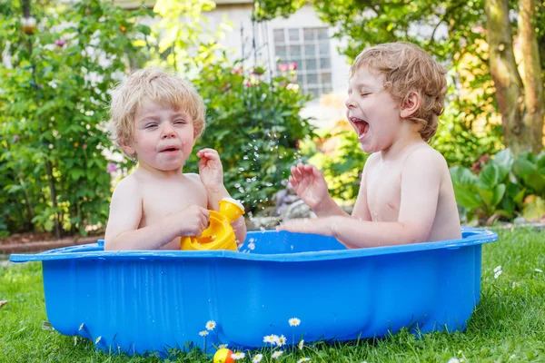 Twee broer of zus jongens plezier maken met water in de zomer — Stockfoto