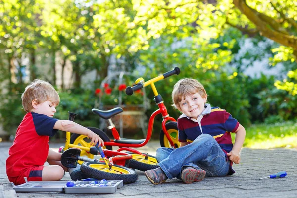 Два младших брата ремонтируют сломанный велосипед — стоковое фото