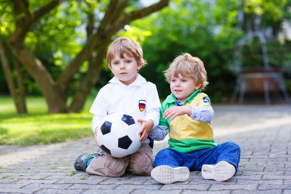 Due piccoli ragazzi ammiratori all'atto di visualizzazione pubblica di gioco di calcio — Foto Stock