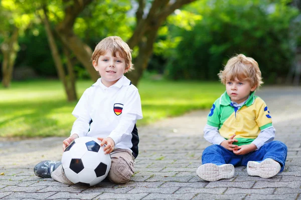 Due piccoli ragazzi ammiratori all'atto di visualizzazione pubblica di gioco di calcio — Foto Stock