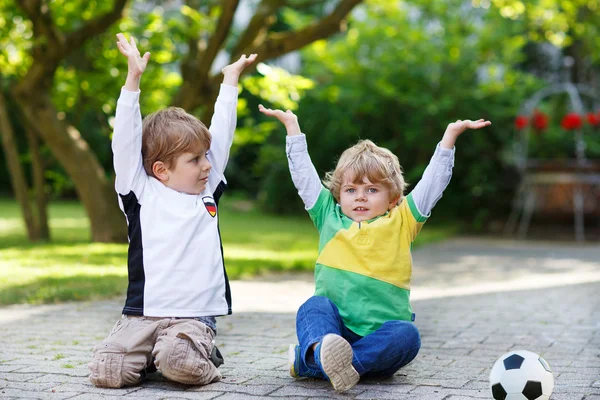 Due piccoli ragazzi ammiratori all'atto di visualizzazione pubblica di gioco di calcio — Foto Stock