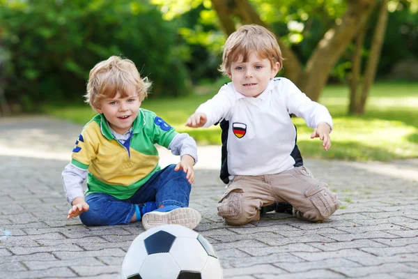 Due piccoli ragazzi ammiratori all'atto di visualizzazione pubblica di gioco di calcio — Foto Stock