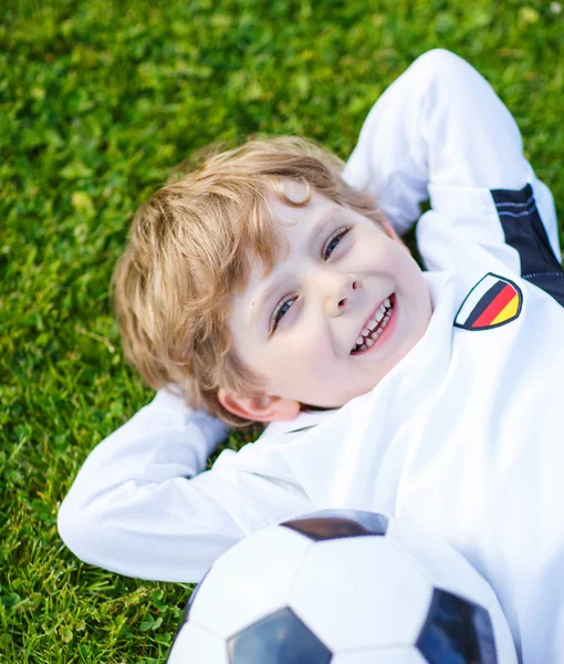 Blond pojke på 4 vilande med fotboll på fotbollsplanen — Stockfoto