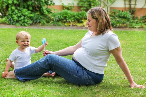 Felice famiglia di due: piccolo bambino e il suo giovane incinta m — Foto Stock