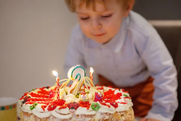 Peuter jongen blazen kaarsen op zijn 2 verjaardag cake — Stockfoto