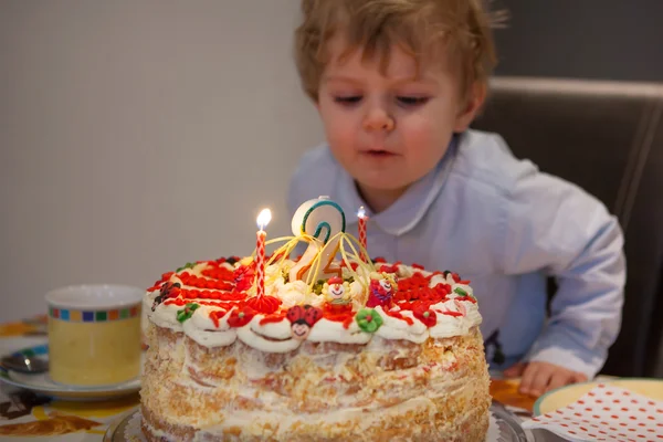 Yürümeye başlayan çocuk mumlar 2 Doğum gününde kek üfleme. — Stok fotoğraf