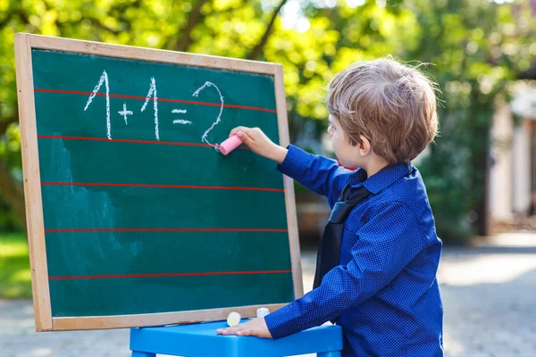 Petit garçon au tableau noir pratiquant les mathématiques — Photo