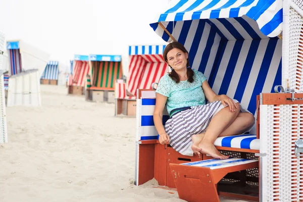 Joven mujer feliz sentado y relajante en la silla de playa en el bea —  Fotos de Stock