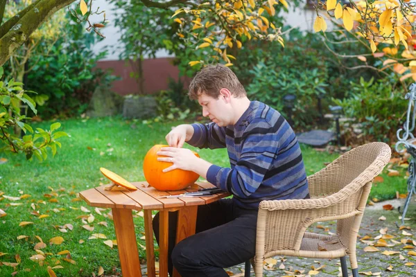 Jovem fazendo abóbora halloween — Fotografia de Stock