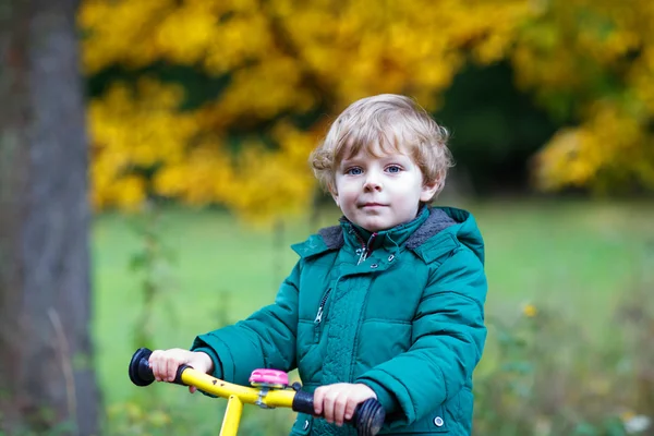 Cute active preschool boy driving on his bike in autumn forest — Stock Photo, Image